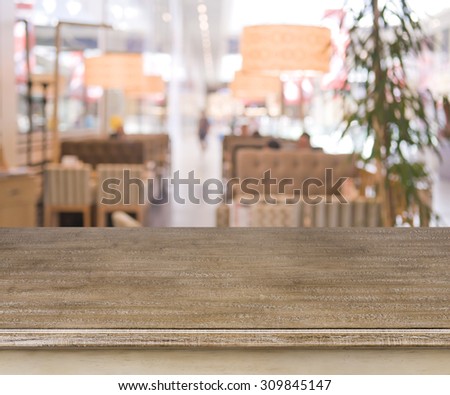 Defocused cafe interior background with wooden table in front