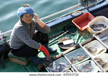 HONG KONG- CIRCA FEB 2009 : An unidentified woman sells fish from her boat circa February 2009 in Hong Kong.