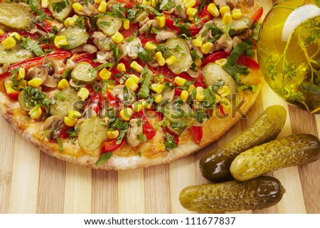 Pizza with pickles, corn, pepper and cheese and ingredients