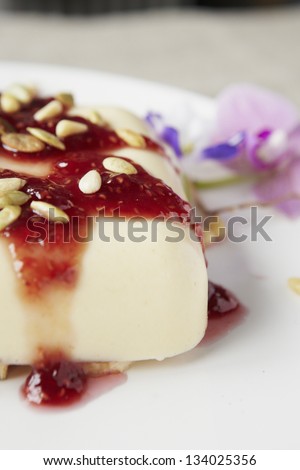 Delicious pudding with seeds and strawberry jam. On a table. Natural lighting