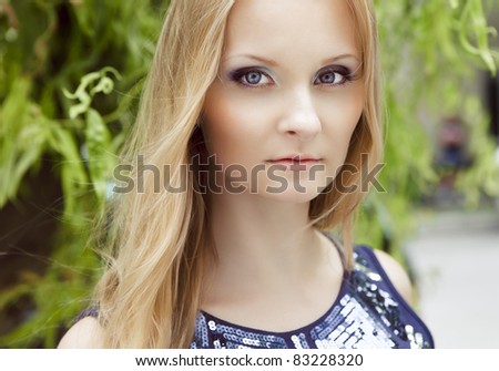 Portrait of beautiful woman in her twenties with natural blond hair and blue eyes, shot outside in sunlight