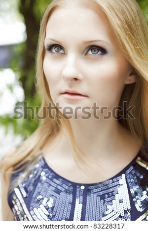 Portrait of beautiful woman in her twenties with natural blond hair and blue eyes, shot outside in sunlight