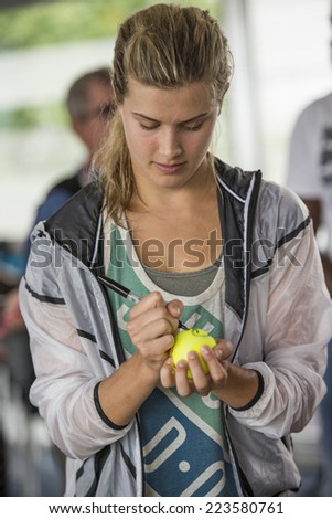 MONTREAL - AUGUST 3: Eugenie Bouchard of Canada signs a tennis ball for a fan at the 2014 Rogers Cup on August 3, 2014 in Montreal, Canada