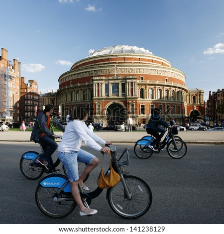 LONDON - MAY 26: Tourists on rental bike passing by Royal Albert Hall on May 26, 2013 in London, UK. London's bicycle sharing scheme launched with 6000 bikes on 2010 to help ease traffic congestion.
