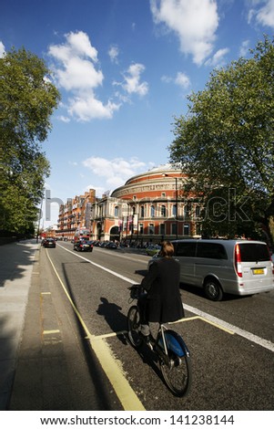 LONDON - MAY 26: Tourists on rental bike passing by Royal Albert Hall on May 26, 2013 in London, UK. London\'s bicycle sharing scheme launched with 6000 bikes on 2010 to help ease traffic congestion.