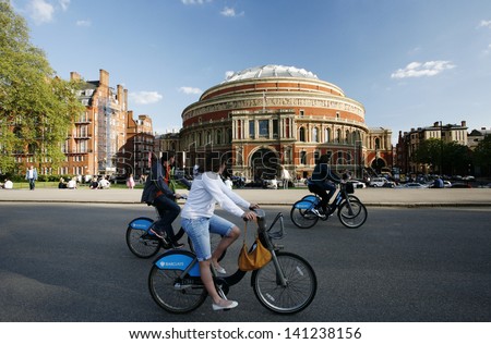 LONDON - MAY 26: Tourists on rental bike passing by Royal Albert Hall on May 26, 2013 in London, UK. London\'s bicycle sharing scheme launched with 6000 bikes on 2010 to help ease traffic congestion.