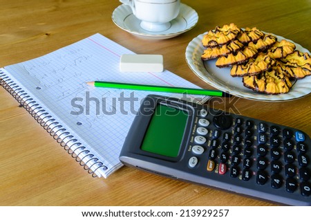 workplace, study place with calculator, workbook, cup of coffee and cookies - stock photo