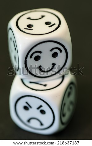 dice with opposite sad and happy emoticon sides - stock photo