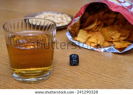 unhealthy snacks on table with skull dice - stock photo