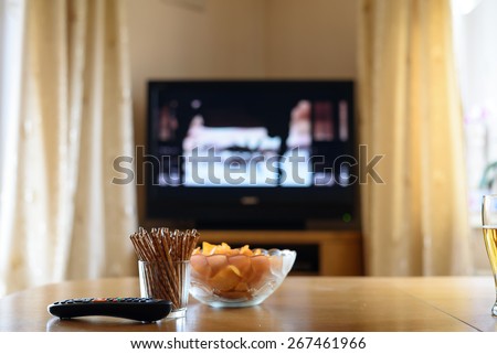 television, TV watching (movie) with snacks lying on table - stock photo