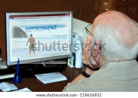 Senior adult dreams about his retirement as he surfs the web at his home office.  Computer screen shows man standing looking at ocean.