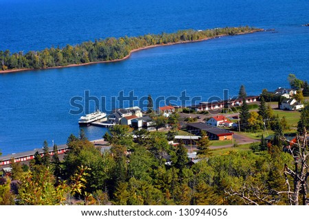 Brockway Mountain Drive overlooks the Isle Royal boat dock and surrounding buildings.  Vivid blue waters of Copper Harbor and Lake Superior fill image.