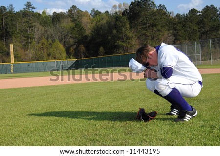 Baseball player commits his game to prayer before beginning of ball game.