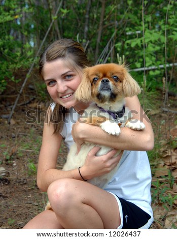 Affection and hugs are everyday for her pet.  Female teen smiles happily.