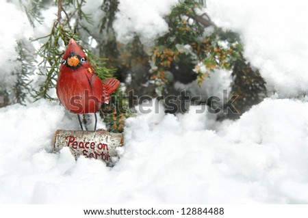 Bright red cardinal wishes peace to the world.  Bird and message sits in snow.