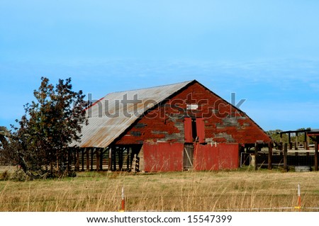 Barn is surrounded by golden field.  Antlers are mounted under the eaves.