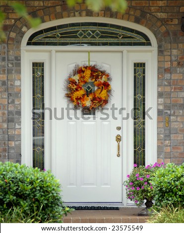 Autumn wreath hangs on exterior of home on entry way door.