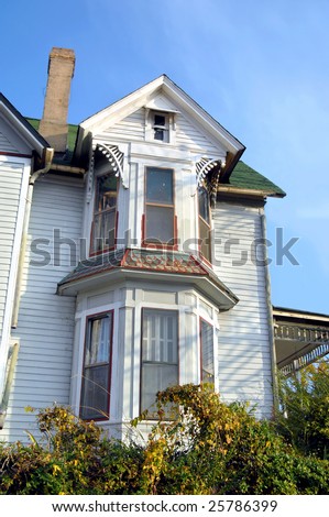 Victorian home with bay windows.  Unusual shingles have metal plates.