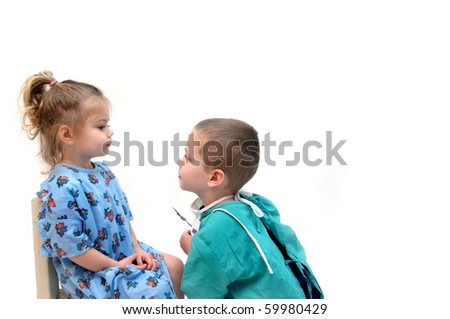 Two little children play doctor.  The little girl is the patient and the little boy is the physician.  He is holding an instrument and beginning the examination.