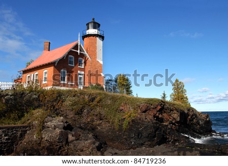 Eagle Harbor Lighthouse is perched on a rocky cliff above Lake Superior.  House and light are of the same brick architeture and joined as one.