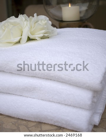 collection of towels and candles and spa accessories at spa with waterfall
