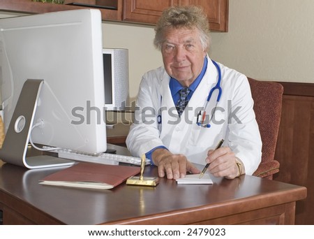 elderly doctor sitting at his desk writing