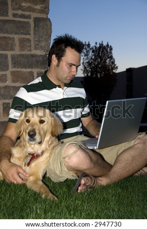 Young student studying with his notebook computer and Golden Retriever dog