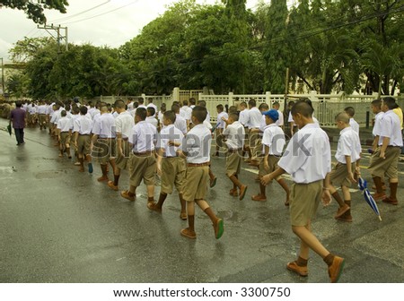 students marching long in the street wearing uniforms