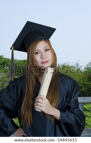 Young woman outdoors with graduation cap and gown