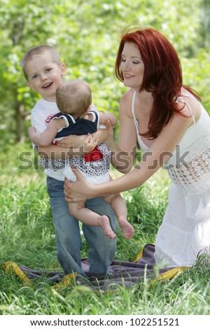 happy mother and two children on natural background