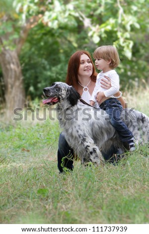 young happy family - mother and child - playing with dog on natural background