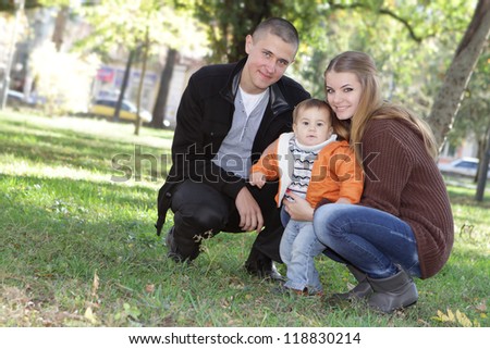 young happy family with child, outdoor portrait on natural background