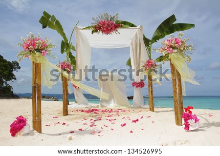 wedding arch and set up with flowers on tropical beach