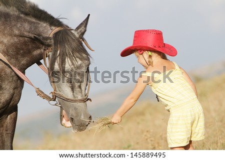girl feeding a horse on farm outdoor portrait