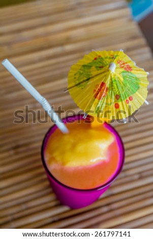 tropical shake, refreshment drink in decorated glass on tropical background