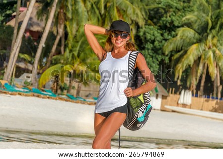 young healthy girl, woman, in sport clothes walking by tropical beach, outdoor portrait