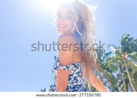 young happy girl with flower bouquet on tropical sea and beach background, smiling happy girl outdoor portrait