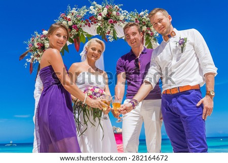 bride, groom and guests enjoying beach wedding in tropics, on wedding arch, setup background