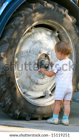 little boy near big truck wheel