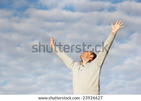 happy man with his hands up on sky background