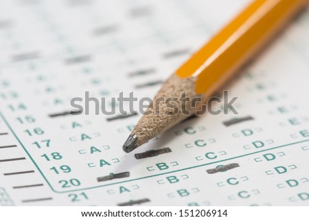 Standardized test form with answers bubbled in and a pencil resting on the paper with a shallow depth of field