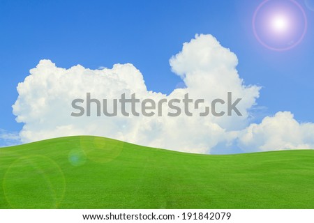 Blue sky green grass and cloud background.