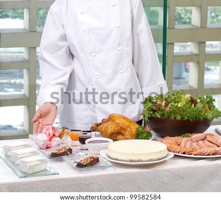 Female chef showing a lot of cooked food and bakery