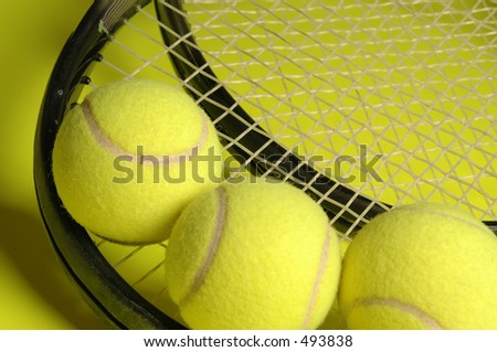 two tennis rackets and three balls on yellow