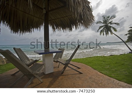 tile table with thatched roof cover by the sea resort corn island nicaragua