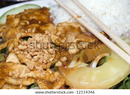 vietnamese food dish sauteed white meat chicken ga sate on spicy sate sauce on pineapple cucumber bean sprouts tomato and crushed peanuts with chop sticks