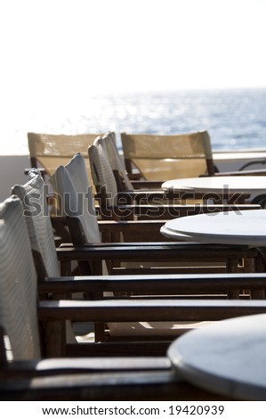 cafe setting by the mediterranean sea on greek island with focus on middle table for fade effect