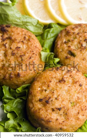 lobster cakes gourmet seafood with lemon wedges tartar sauce on bed of leafy lettuce