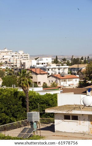 rooftop cityscape view of Larnaca Cyprus hotels condos apartments offices with Mediterranean sea and mountains in distance vertical