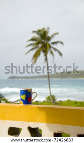 colorful coffee cup on wall view Caribbean Sea and palm tree Corn Island Nicaragua